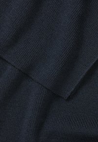 Tessuto a maglia navy con una fine texture a coste, che mostra sezioni sovrapposte e una superficie liscia, evidenziando la consistenza del colore e i dettagli del materiale.
