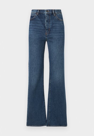 Magas derekú sötétkék farmernadrág elöl gombos, cipzáras, ötzsebes kialakítással és széles, bővülő szárakkal.