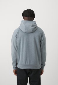 Gray hoodie with a relaxed fit, features a large hood, ribbed cuffs, and hem. Smooth texture, plain design, and no visible patterns.