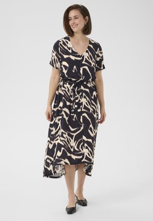 Robe maxi noire avec un motif abstrait crème, manches courtes, décolleté en V, ceinture à nouer et ourlet asymétrique. Tissu léger.
