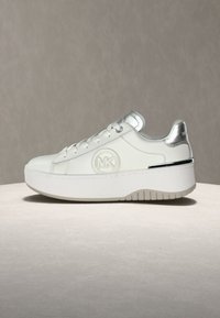Άσπρο δερμάτινο αθλητικό παπούτσι με ασημένιες λεπτομέρειες, στρογγυλεμένη μύτη, μαξιλαρωμένο πέλμα και λογότυπο MK. Παχύ λευκό πέλμα με υφή για καλύτερη πρόσφυση.