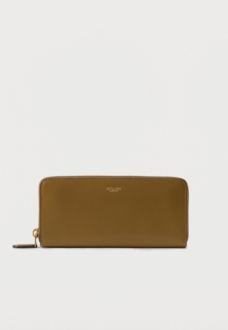 Ορθογώνιο πορτοφόλι από ταμπά δέρμα με φερμουάρ σε όλη την περίμετρο σε χρυσό τόνο και μικρό ανάγλυφο λογότυπο "Coach New York" στο κέντρο της μπροστινής πλευράς.