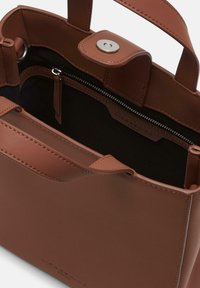 Brązowa skórzana torebka z dwoma uchwytami, z bezpiecznym zapięciem na zatrzask i wewnętrzną kieszonką na zamek; gładka tekstura i minimalistyczny design.