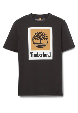 T-shirt nera a maniche corte con un grande logo Timberland che mostra un albero stilizzato all'interno di un quadrato color cuoio sopra il nome del marchio in testo nero.