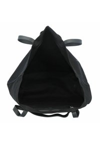 Svart canvasbärkasse med stort öppet topp, texturerad inredning och smala axelremmar. Har en minimalistisk design och inga externa fickor.