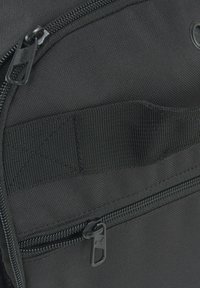 Bolso negro con una tela texturizada, doble cremallera y una correa de red para sujeción. Incluye un compartimento con cremallera segura.