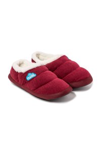 Zapatillas de corduroy rojas con un suave forro de piel blanca y una insignia en azul. Tienen una punta redondeada y una suela marrón flexible.