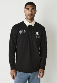 Schwarzes Langarm-Polohemd mit weißem Kragen, ausgestattet mit einem Felix der Kater-Graphic und Text auf der linken Brust. Aus Baumwollmaterial.
