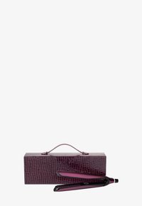 Paarse krokodillenembossed tas met een handvat bevat slanke zwarte stijltangen. Het ontwerp heeft een gladde, glanzende afwerking en subtiele accenten.