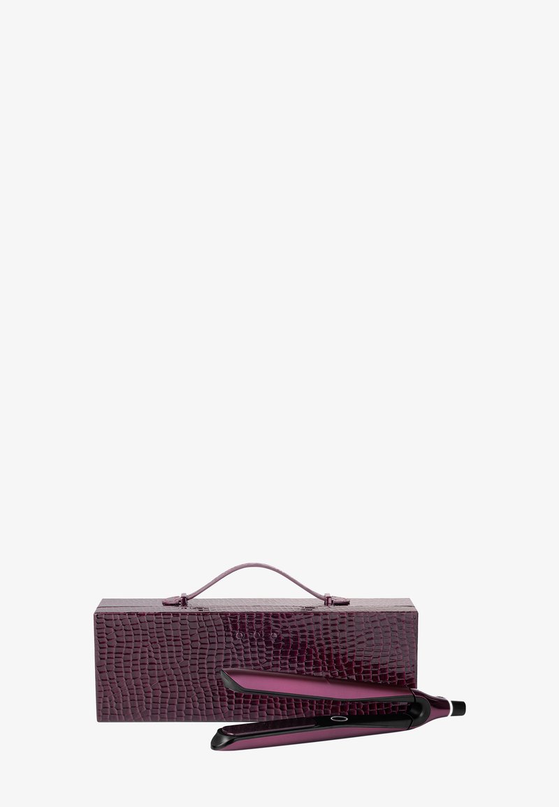 Paarse krokodillenembossed tas met een handvat bevat slanke zwarte stijltangen. Het ontwerp heeft een gladde, glanzende afwerking en subtiele accenten.