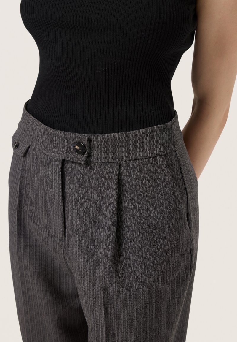 Pantalons gris à rayures avec une coupe ajustée, dotés de plis avant, de deux poches latérales et de deux accents en bouton à la taille.