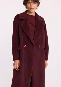 Burgundzkie dwurzędowe płaszcze z miękkiego materiału z dużymi klapami, dwiema guzikami i bocznymi kieszeniami, charakteryzujące się luźnym krojem i prostą sylwetką.