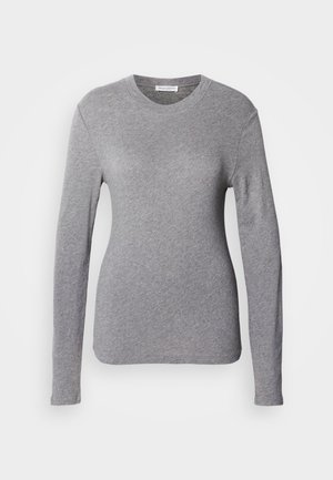 Siva majica dugih rukava napravljena od mekog materijala, sa okruglim izrezom i prilagođenim krojem. Glatka tekstura bez vidljivih uzoraka ili detalja.