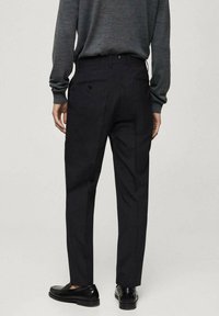 Sorte skræddersyede bukser med en slim fit, der har en flad front, to baglommer og en glat tekstur, parret med sorte loafers.