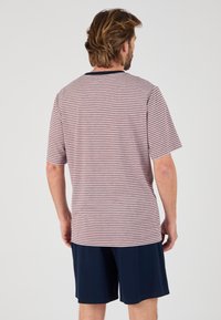 Gestreepte korte mouwen t-shirt in lichtgrijs en kastanjebruin, gecombineerd met marineblauwe shorts. T-shirt heeft een ronde hals en een relaxed fit.