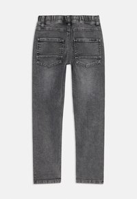 Jean en denim gris à la coupe slim, doté d'une taille élastique, de deux poches arrière et d'une finition texturée. Pas de poches avant visibles.