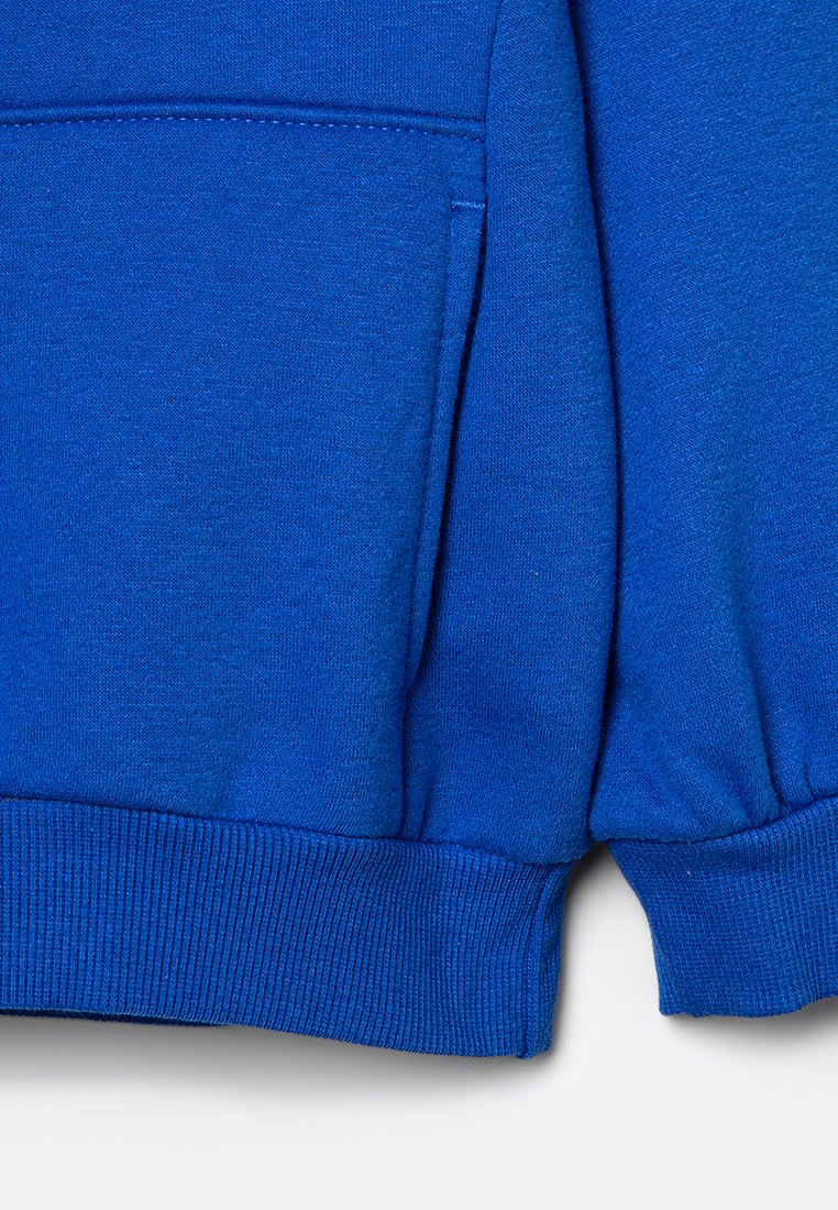 Sudadera azul con una textura suave, puños acanalados y un bolsillo tipo canguro, diseñada para la comodidad y el calor.