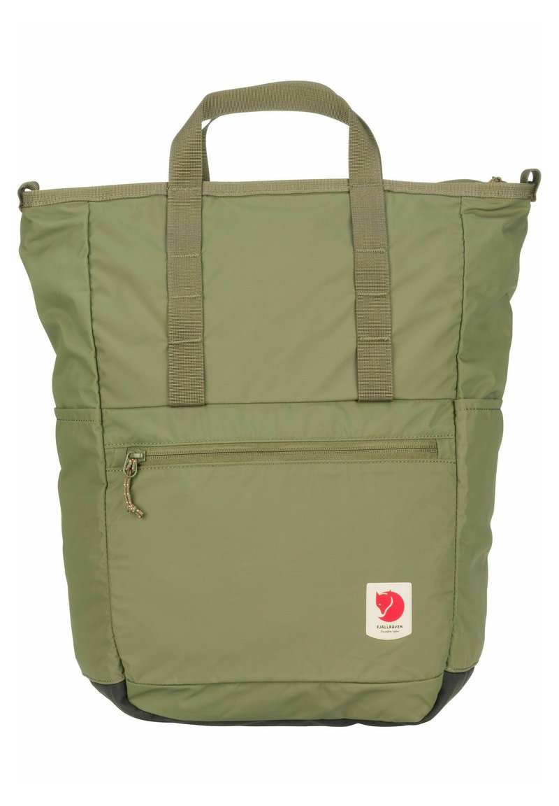 Bolsa tote de nylon verde con dos asas superiores, un bolsillo frontal con cremallera y un parche con el logo. Presenta una textura suave y una forma rectangular.