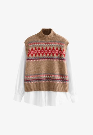 Stickad ärmlös tröja i beige med röda, blå och vita geometriska mönster. Har en ribbad halsringning och nederkant, lagd över en vit skjorta med krage.
