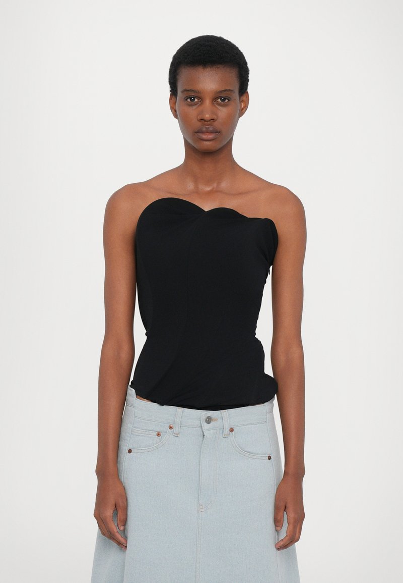 Black strapless top with a sweetheart neckline, featuring a fitted design and smooth texture, paired with a light blue denim skirt.