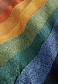 Strukturirana pletenina v horizontalnih črtah rdeče-rjave, gorčične, zelene, teal, modre in črne barve. Vsaka barva ima mehak, raznolik teksturo.