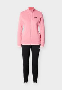 Ροζ φούτερ με φερμουάρ και ψηλό γιακά, με μαύρο λογότυπο. Συνδυασμένο με μαύρο παντελόνι, και τα δύο από απαλό ύφασμα και casual γραμμή.