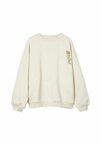 Sudadera color crema con cuello redondo, hombros caídos, puños acanalados y un logo bordado en múltiples colores "DESIGUAL" en la manga izquierda.