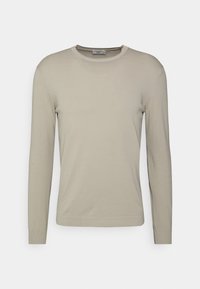 Vaalean beige pitkähihaine villapaita, joka on valmistettu pehmeästä kankaasta. Siinä on pyöreä kaula-aukko ja ribbineuleiset hihansuut. Yksinkertainen, selkeä muotoilu.