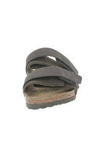 Sandal noir foncé avec des lanières croisées, en suede, semelle en liège, forme contourée, semelle extérieure texturée et fermeture ajustable.