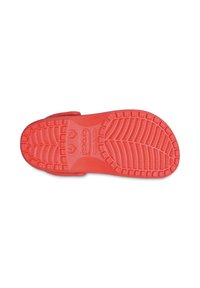 Red rubber shoe sole with a textured pattern, featuring deep grooves and the brand name "crocs" embossed prominently.