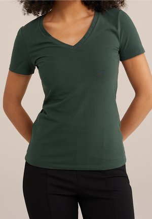 Ciemnozielona, krótki rękaw, koszulka typu V, wykonana z miękkiego materiału, zestawiona z czarnymi dopasowanymi spodniami. Gładka tekstura i prosty design.
