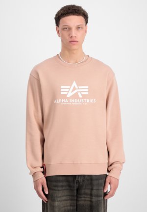 Rosa Sweatshirt aus weichem Stoff, mit einem weißen Logo und Grafik auf der Vorderseite. Gerippte Bündchen und Saum mit einem Etikett an der unteren Seite.