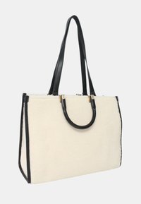 Borsa a spalla con corpo in pelliccia sintetica crema, manici in pelle nera lucida e rifiniture nere eleganti. Presenta accessori in metallo dorato e una forma rettangolare.