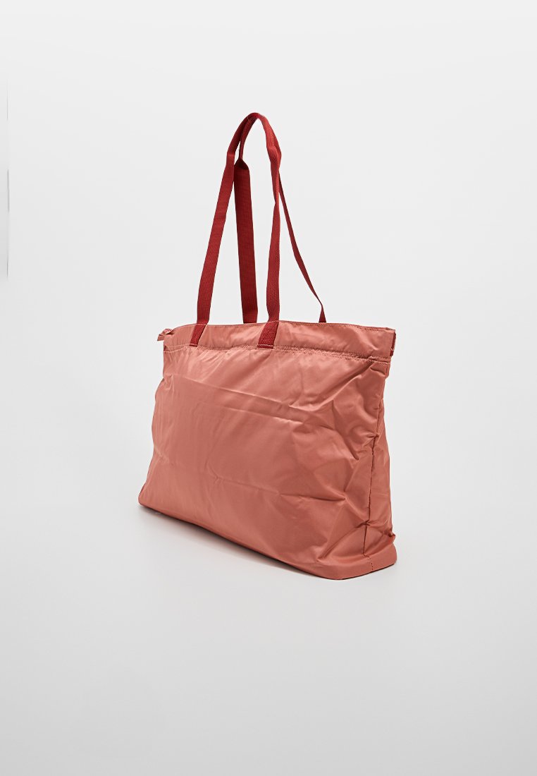 Bolso de mano suave y rosa en tela ligera con asas rojas, que presenta una forma rectangular estructurada y un diseño minimalista.