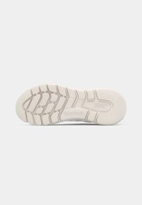 Suela de zapatilla de goma blanca con patrones de tracción texturizados y el logo de Reebok. Superficie lisa con ranuras distintivas para un mejor agarre.