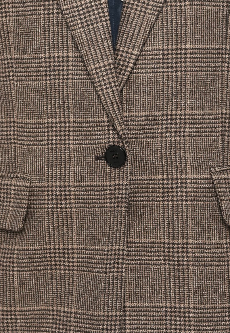 Blazer a quadri marrone con rever a punta, due tasche frontali e un solo bottone nero. Realizzato in un tessuto testurizzato, presenta motivi a quadri contrastanti.