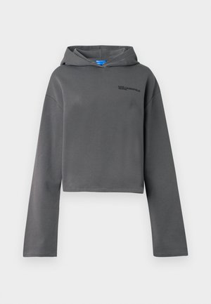 Grau geschnittene Kapuzenjacke aus weichem Material, mit Kapuze und langen Ärmeln. Auf der Vorderseite sich befindendes, schwarzes gesticktes Logo, minimalistisches Design.