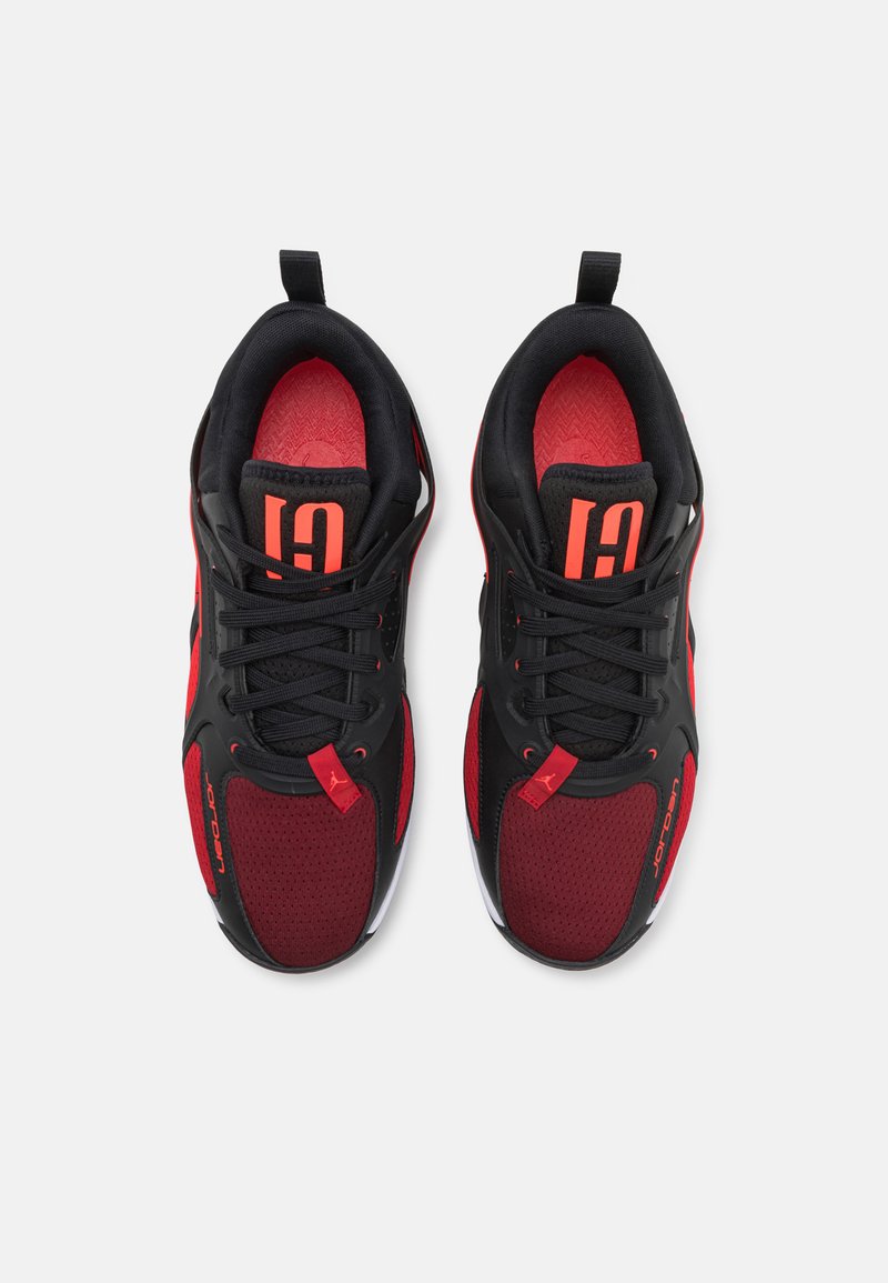 Schwarze und rote Sportschuhe mit einem Obermaterial aus Mesh und Gummi, ausgestattet mit einer strukturierten Sohle, gepolstertem Schaft und auffälligen Branding-Akzenten.
