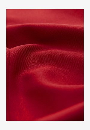Czerwona tkanina, teksturowana powierzchnia z gładkim wykończeniem, prezentująca miękkie fałdy i subtelny blask. Splot jest ciasny i równomierny w całej powierzchni.