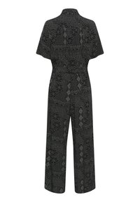 Black patterned jumpsuit with short sleeves, wide-leg design, and a tied waist. Features textured floral and abstract designs in white.