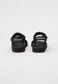 Svarta sandaler med justerbara remmar, platt gummisula och varumärkeslogotyp på hälen. Har en strukturerad innersula för grepp.