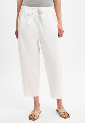 Weiße Baumwollhosen mit elastischem Bund und Kordelzug, mit lockerer Passform und verkürzter Länge. Getragen mit beigen flachen Sandalen.