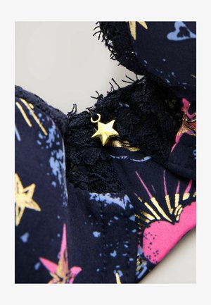 Reggiseno blu navy con motivi a stelle e esplosioni, dotato di rifiniture in pizzo e un accento dorato a forma di stella vicino al cinturino. Morbido al tatto.