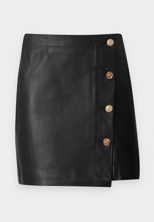 Μαύρη μίνι φούστα από ψεύτικο δέρμα με ασύμμετρο μπροστινό μέρος και τέσσερα διακοσμητικά χρυσά κουμπιά στη δεξιά πλευρά.