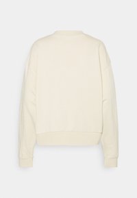 Sweat-shirt couleur crème à col rond, manches longues, poignets et ourlet côtelés, présenté de dos sur un fond uni.