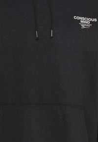 Sudadera negra de tejido suave, con un bolsillo frontal, cordón ajustable y logo de texto blanco en el pecho.