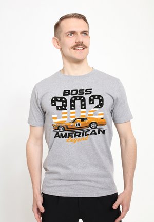 Camiseta de algodón gris con un estampado gráfico de un coche naranja y el texto "BOSS 302 AMERICAN Legend", con acentos en negro y naranja.