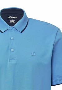 Hellblaues Polo-Shirt aus strukturiertem Stoff, mit dunkelblauem Kragen, zwei Knöpfen und einem gestickten Logo auf der Brust.