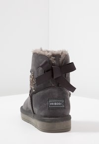 Šedá z semišové kůže kotníková bota s umělou kožešinou uvnitř, zdobená výšivkou a černou stuhou na zadní straně. Plně gumová podešev.