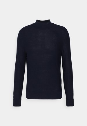 Marineblaues Strickpullover mit einem ribbeligen Rollkragen, langen Ärmeln und einem dezenten Frontlogo. Hergestellt aus einem glatten, leichten Stoff.